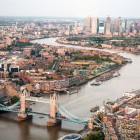 A photo of London takes from a helicopter showing the Thames river, London Bridge and several sky scrapers.